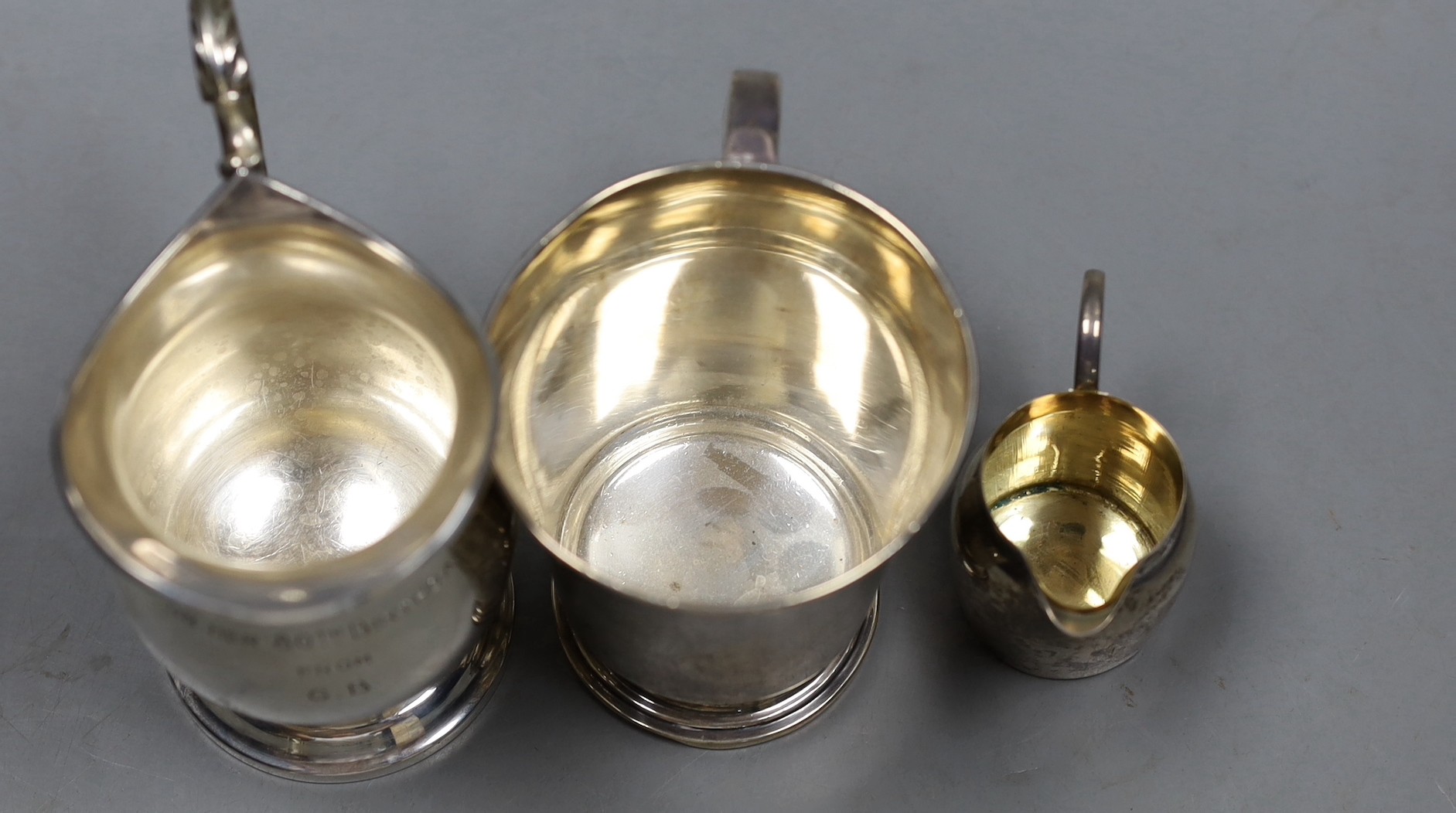 A 1960's silver cream jug, a small cream jug and a George V silver christening mug, 9.5 oz.